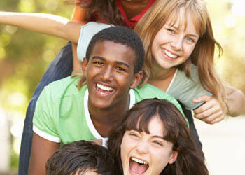 Group Of Teenagers Having fun Piled Up In Park