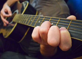 Close Up Of Guitarist Playing Acoustic Guitar
